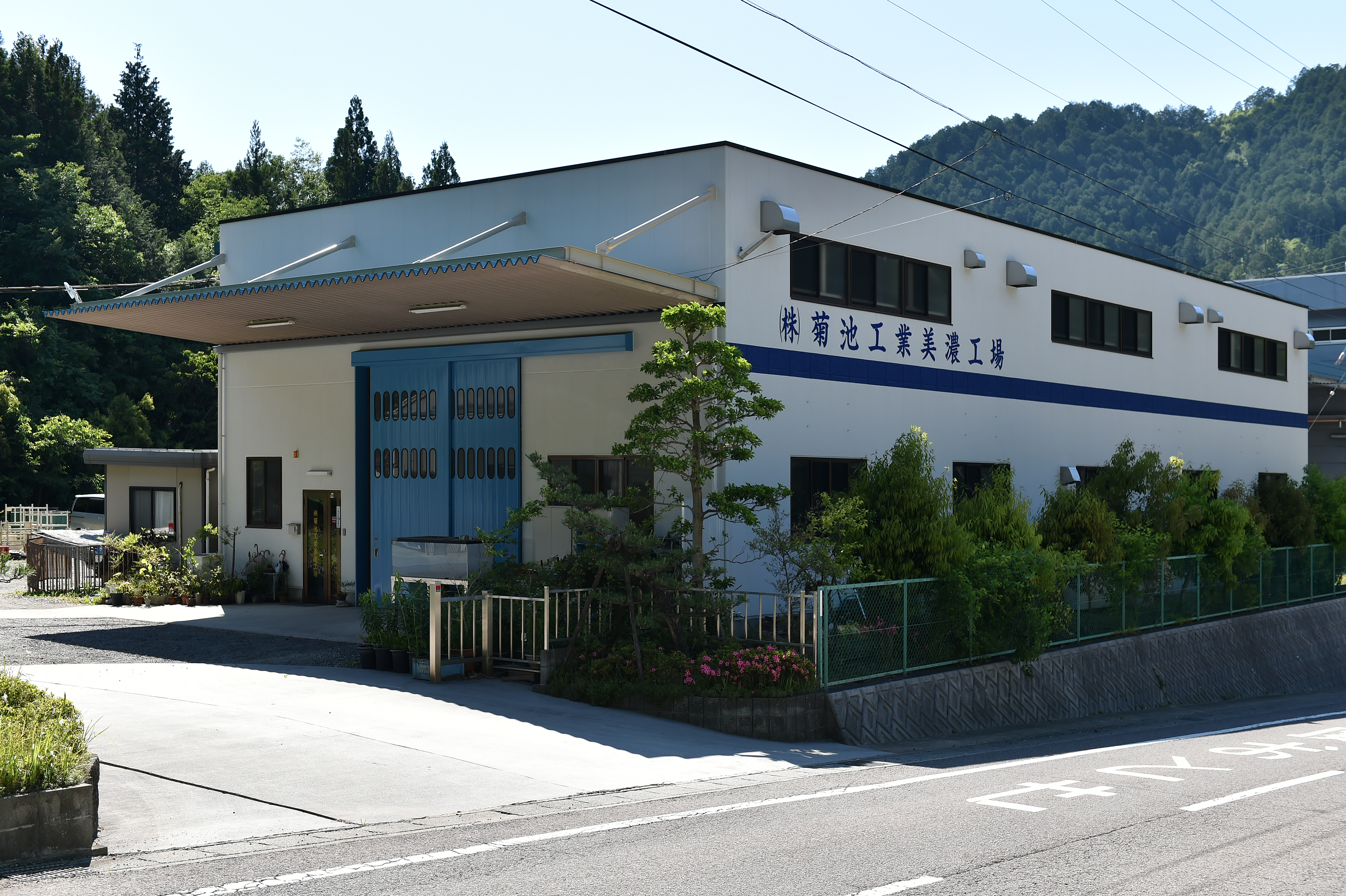 金属板を加工する工場内の作業台と設備が並ぶ広い作業空間